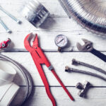 plumbing tools and accessories on wooden table. top view